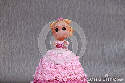 Princess doll cake with dress made of cream on grey background Stock Photo