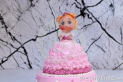 Princess doll cake with dress made of cream on marble pattern background Stock Photo