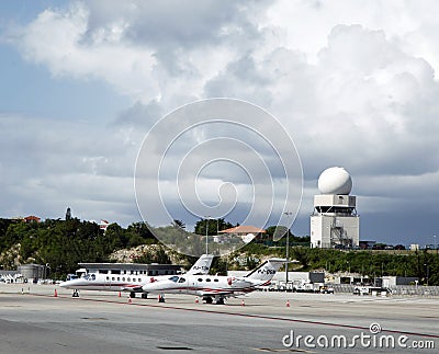 Private jets and traffic control tower in Princess Juliana Airport , St. Maarten Editorial Stock Photo