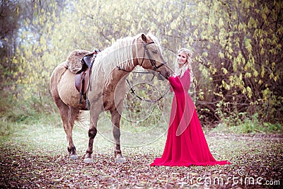 Princess in red dress with horse in fall, autumn. Fairy tale, fantasy. Stock Photo