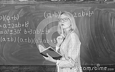 Principles can make teaching effective. Woman teaching near chalkboard in classroom. Effective teaching involve Stock Photo