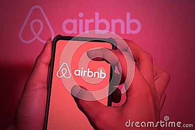 Hand close-up. This photo illustration shows the airbnb logo on a phone screen. clippingpath Cartoon Illustration