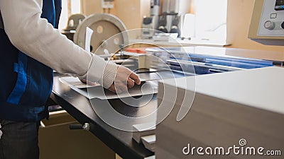 Print operator pulls printed sheet of paper Stock Photo