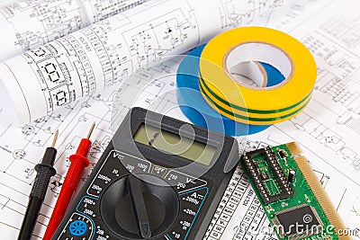 Printed drawings of electrical circuits, digital multimeter, electronic board and insulating tape. Stock Photo