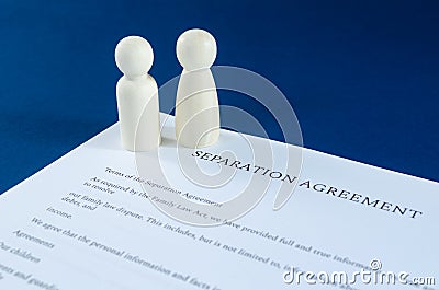 Printed separation agreement with male and female wooden figures in a conceptual image for divorce Stock Photo