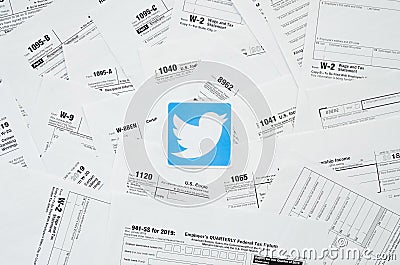 Printed Twitter logo on many tax form blanks lies on table close up. Help with tax problems using internet and information from Editorial Stock Photo