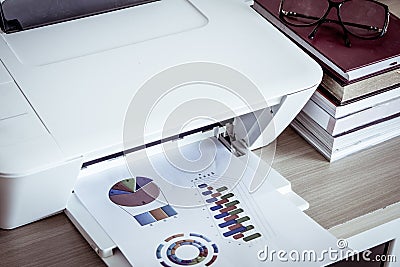 Printer with eyeglasses on books on wooden table Stock Photo