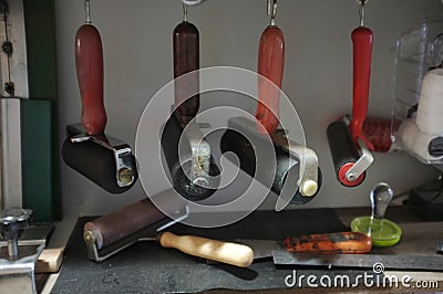 Printmaking rollers hanging on an art studio wall Stock Photo