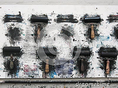 Printmaking rollers hanging on an art studio wall in the messy workshop Stock Photo