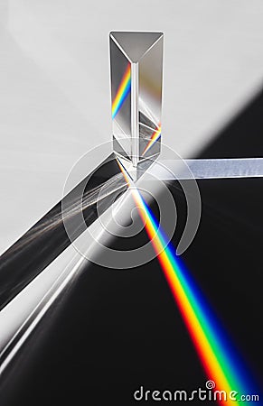 A prism dispersing sunlight splitting into a spectrum on a white background. Stock Photo