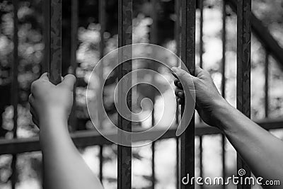 Prison cell: Close up of hands in jail Stock Photo