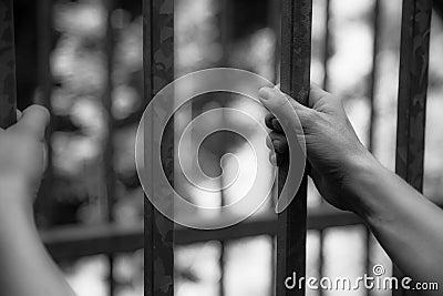 Prison cell: Close up of hands in jail Stock Photo