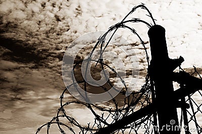 Prison Fence Against Dark Sky Stock Photo