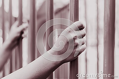 Prison hands holding Steel cage jail bars. Stock Photo
