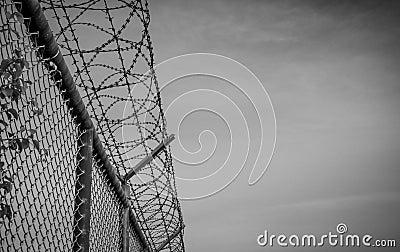 Prison security fence. Barbed wire security fence. Razor wire jail fence. Barrier border. Boundary security wall. Prison Stock Photo