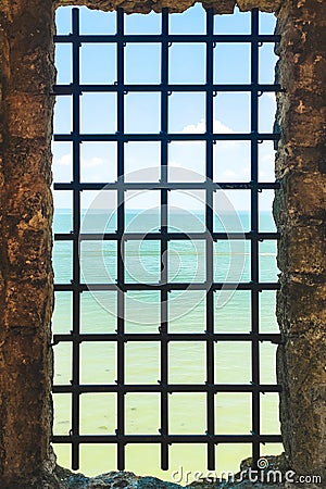 prison window bars in the castle overlooking the sea. Stock Photo