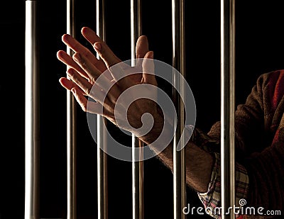 Prisoner behind bars Stock Photo