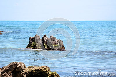 Pristine beach and beautiful rocks in the azure sea Stock Photo