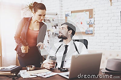 Private detective agency. Man and woman are talking, drinking coffee. Stock Photo