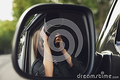 Private detective with camera spying from auto, view through car side mirror Stock Photo