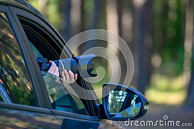 A private detective is sitting in the car, filming. The paparazzi sits in the car and photographs a famous person. Spy with a Stock Photo