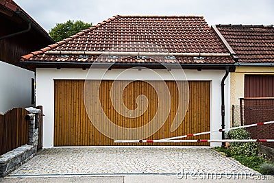Private garage with barrier, wooden gate Stock Photo