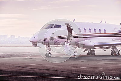 Private jet plane parking at the airport. Private airplane at sunset, Stock Photo