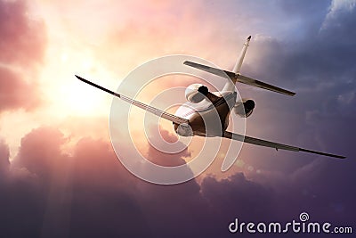 Private Jet PLane in the sky at sunset Stock Photo