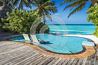 Private oceanfront pool with submerged loungers in a luxury resort Stock Photo