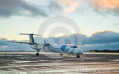 Private propeller-driven airplane parking at the airport with sunset background. Stock Photo