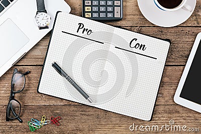 Pro and Con lists in note pad on office flat lay Stock Photo