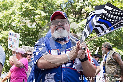 Conservative Demonstrator Hold Up Thin Blue Line Flags as Police Officers Deal with Counter-Protestor Editorial Stock Photo