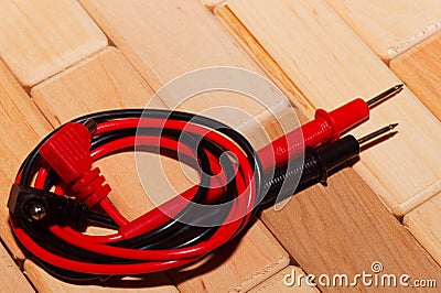 Probes of a digital multimeter on the floor of wooden planks Stock Photo