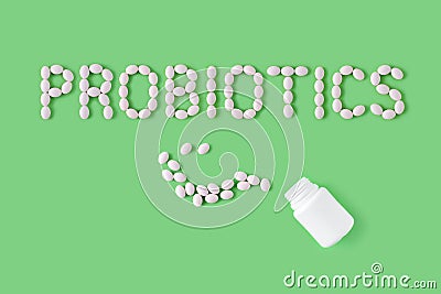 Probiotics word made of pills on green background. Flat lay, top view, free copy space. Stock Photo