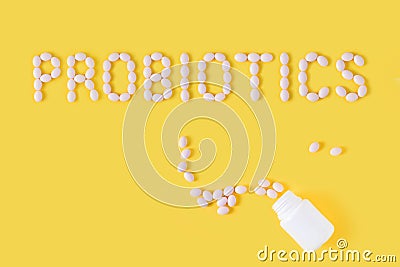 Probiotics word made of pills on yellow background. Flat lay, top view, free copy space. Stock Photo