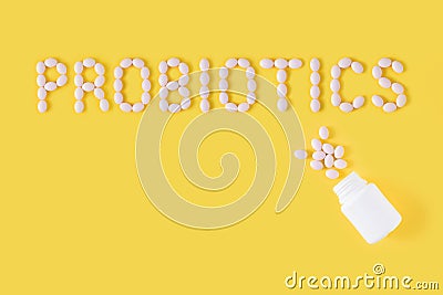 Probiotics word made of pills on yellow background. Flat lay, top view, free copy space. Stock Photo