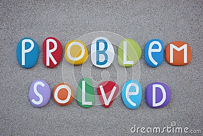 Problem solved, creative text composed with multi colored stone letters over beach sand Stock Photo
