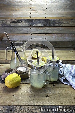 Proccess of making detox water with lemon in a glass jar with a handle, lid, and straw Stock Photo