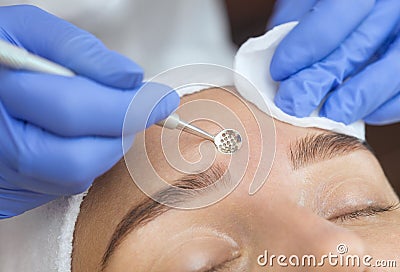 Procedure for cleaning the skin of the face with a steel appliance with a spoon from blackheads, acne Stock Photo