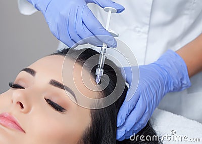 Procedure of mesotherapy. The doctor cosmetologist makes the procedure of mesotherapy in woman`s head. Stock Photo