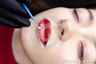The procedure of permanent lip tattooing is applying matter to the lips anesthesia with a small brush Stock Photo