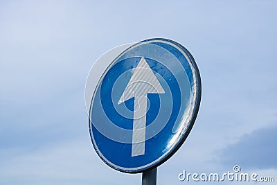 Proceed straight only direction sign on cloudy sky background. Stock Photo