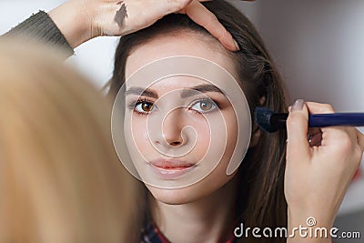 Process of applying makeup on the girls face Stock Photo