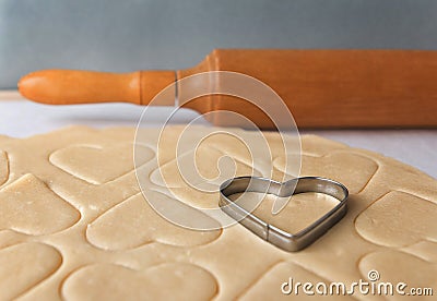 The process of baking cookies at home.Heart shaped cookie cutters cutting out holiday sugar cookies. St. Valentines Day. Side view Stock Photo