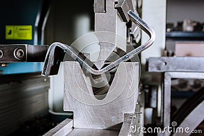 Sheet metal bending on a hydraulic bending machine. Metal part after bending Stock Photo