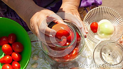 The process of canning pickles tomatoes.put tomatoes in a jar Stock Photo