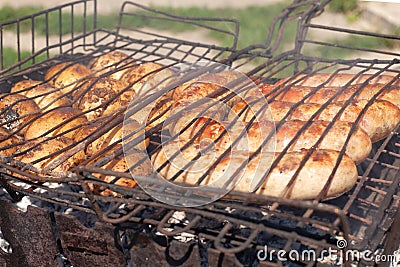 The process of cooking meat sausages on the grill,charcoal fried potatoes Stock Photo
