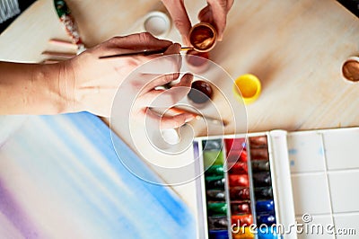 The process of creating an illustration by the artist. Watercolor paint.Hand with brush Cartoon Illustration