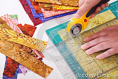 Process cutting fabric pieces by rotary cutter on mat using ruler Stock Photo