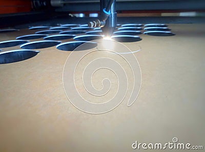 The process of cutting a round shape with a lasser machine. Laser beam penetrates acrylic material Stock Photo